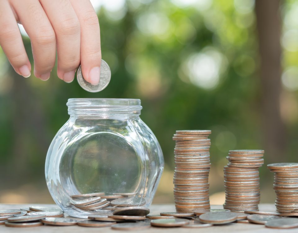 Hand putting money coin stack growing business.